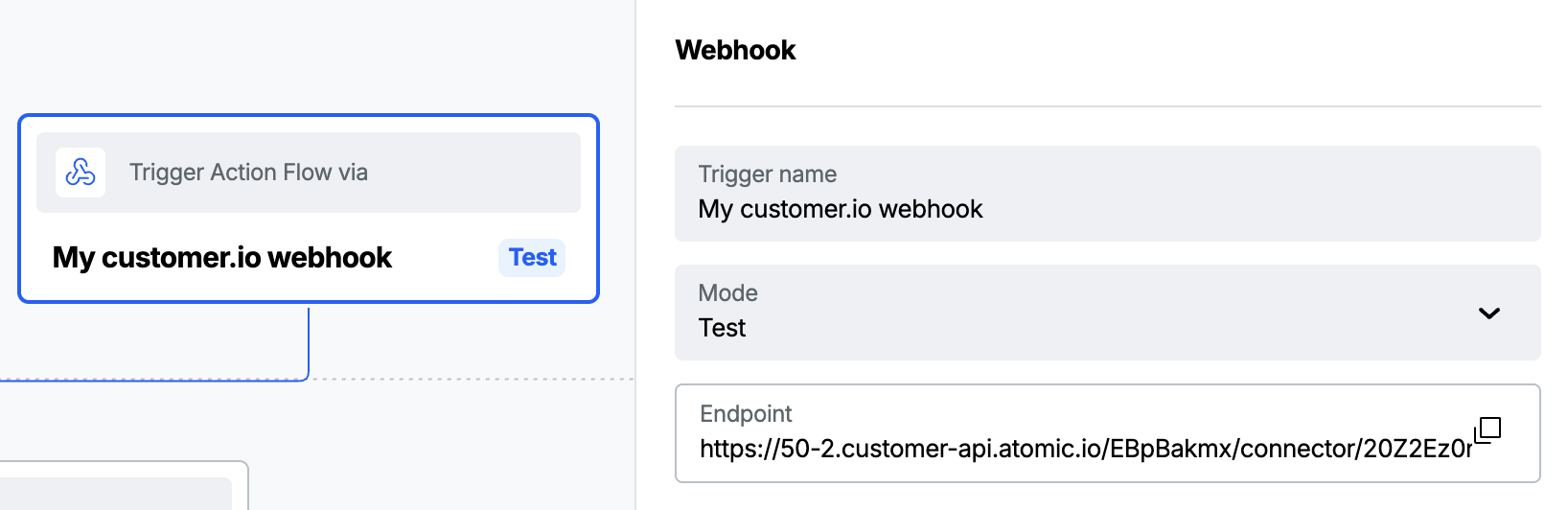 An Atomic Action Flow canvas with a Webhook trigger selected. The properties panel shows the trigger name, its mode set to Test, and the generated endpoint URL.